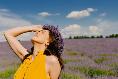 Young woman standing against sky