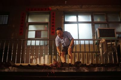 Full length of man standing against window