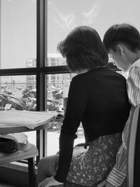 Rear view of couple sitting on table