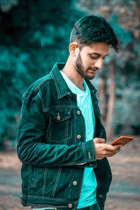 Young man using mobile phone outdoors