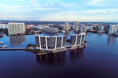 Modern buildings by sea against sky in city