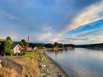 Scenic view of river by buildings against sky