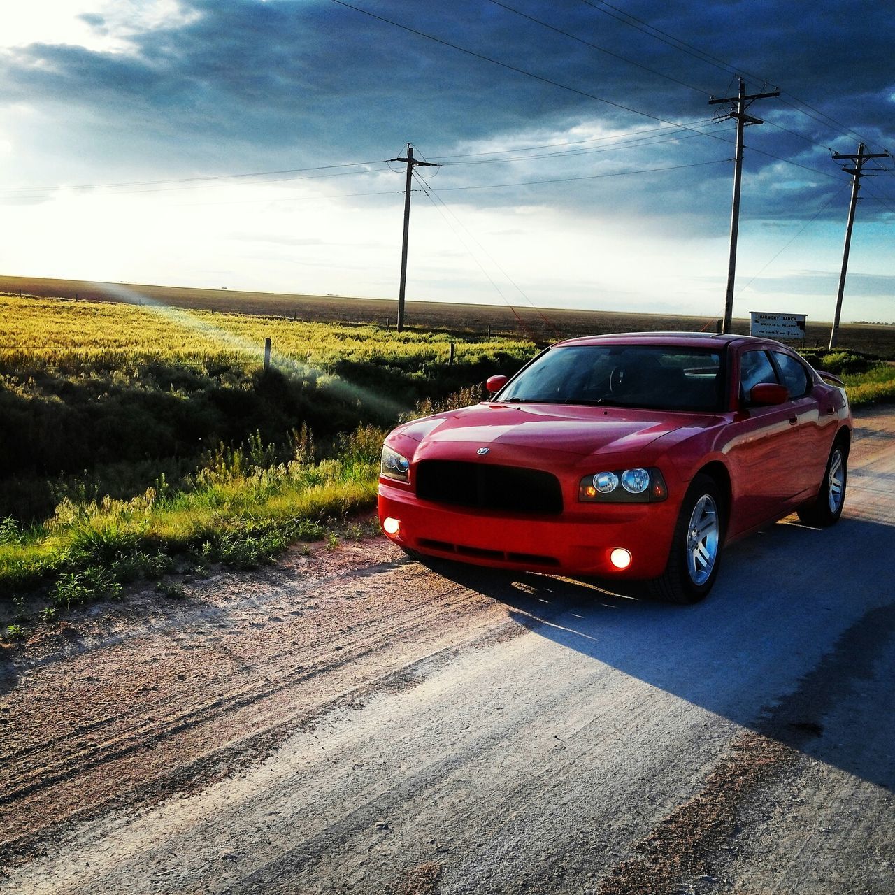 transportation, sky, mode of transport, electricity pylon, landscape, land vehicle, cloud - sky, power line, car, field, road, cloud, cloudy, grass, travel, nature, outdoors, rural scene, no people, electricity