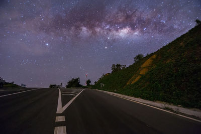 Empty road against sky at night