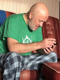 Bald man sitting on sofa