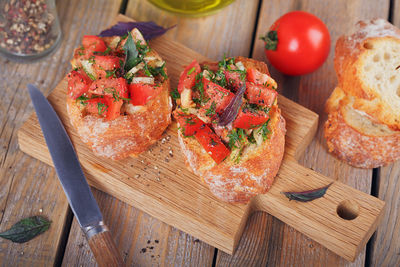 Italian bruschetta with chopped tomatoes, basil, herbs and olive oil on grilled crusty bread