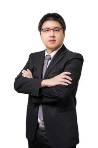 Portrait of young man standing against white background