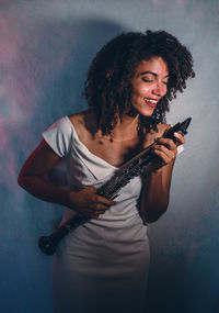 Portrait of young woman standing against sky