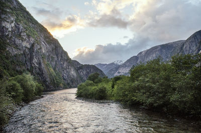 Scenic view of river amidst mountains against sky