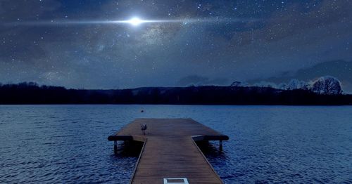 Scenic view of lake against sky at night