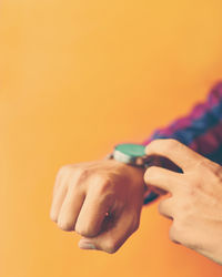Cropped hands against yellow background