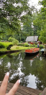 Reflection of person in boat on lake against trees