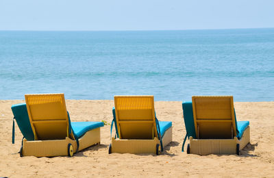 Chairs on beach against sky