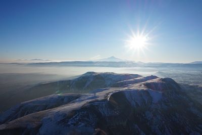 Scenic view of snowcapped mountains during sunny day