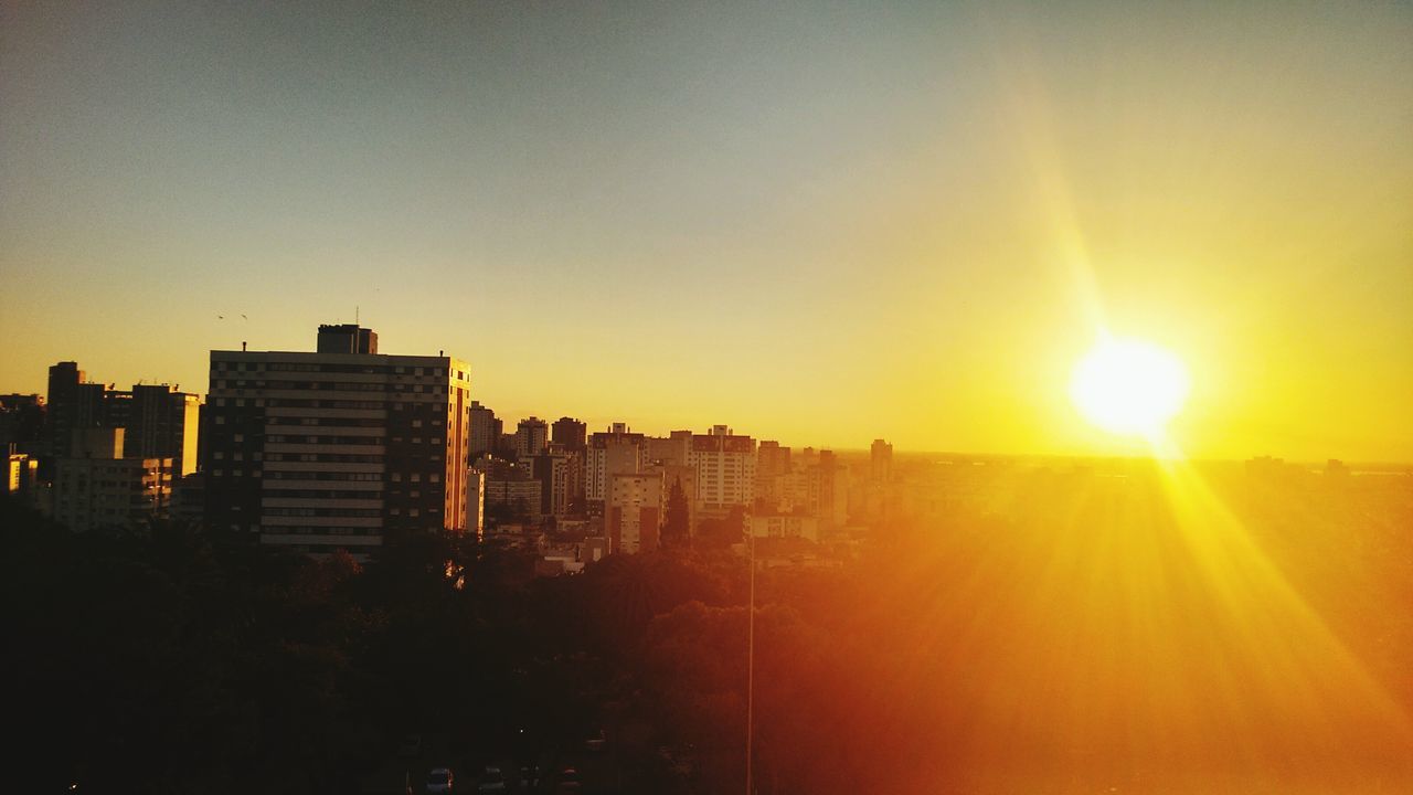 sunset, sun, building exterior, architecture, built structure, city, orange color, sunlight, clear sky, copy space, cityscape, sunbeam, lens flare, silhouette, residential building, sky, building, bright, residential structure, skyscraper