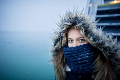 Portrait of woman wearing fur coat in boat on sea during winter