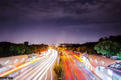 Light trails on road against sky at night