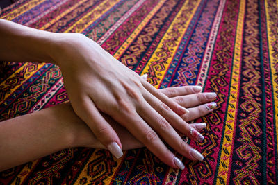 High angle view of hands on rug