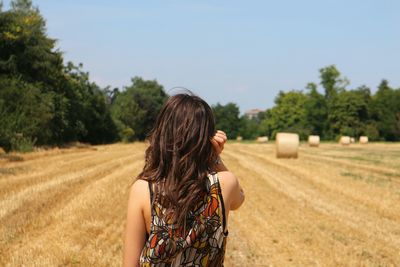 Rear view of woman walking on field