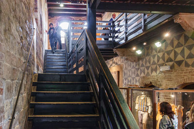 Low angle view of people standing on staircase in building