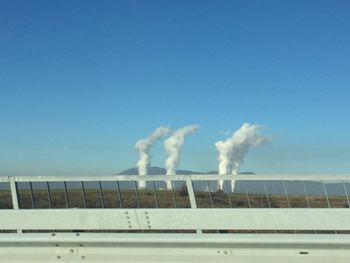 Smoke emitting from chimney against clear sky