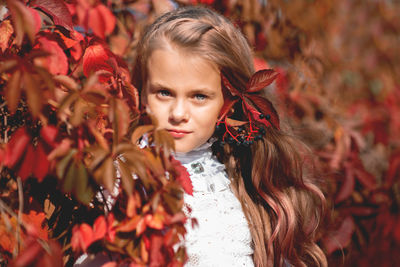 Portrait of girl with red leaves during autumn