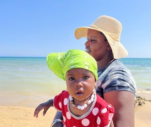 Portrait of cute girl wearing hat at beach