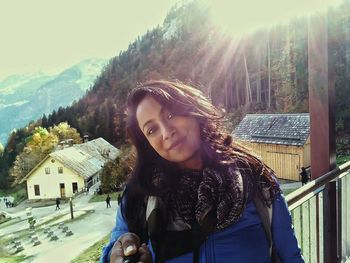 Portrait of smiling young woman standing on snow covered house