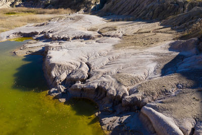 Abandoned opencast mine and waste lake. cracked mud pattern, erosion, contaminated water in pond