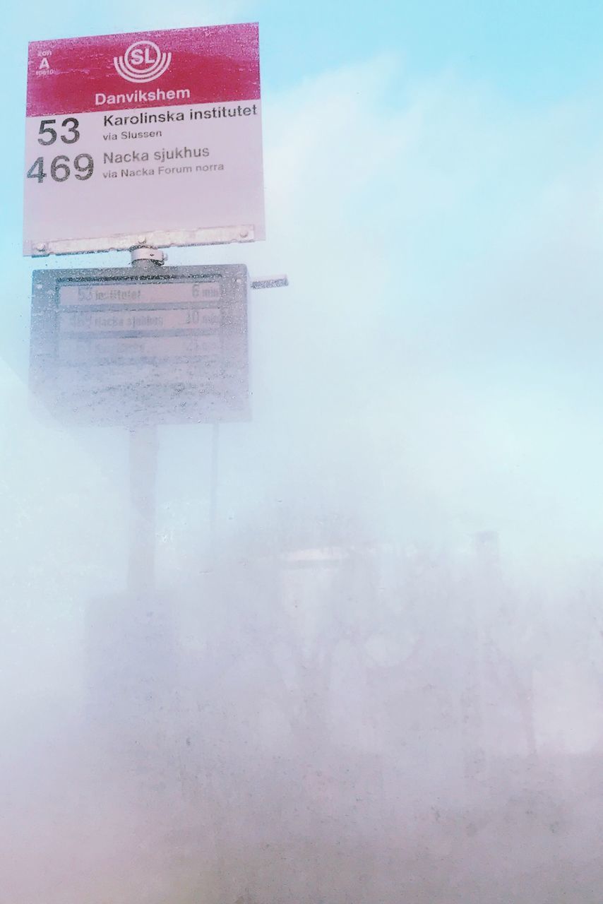 CLOSE-UP OF ROAD SIGN ON SNOW