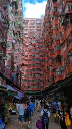 People walking on street amidst buildings in city