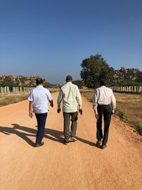 Rear view of people walking on road