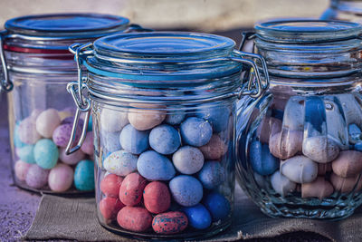 Glass jars filled with easter candies pastel color mini candy eggs and jelly beans