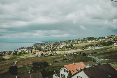 High angle view of houses by sea against sky