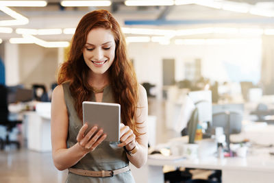 Young woman using smart phone in laptop