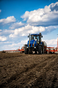 Tractor on agricultural field against sky