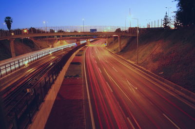 Light trails on road in city against sky at night