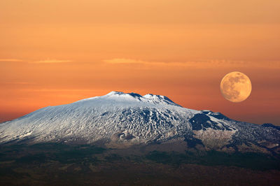 Scenic view of snowcapped mountain against sky during sunset