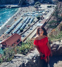 Woman standing by stone wall against beach