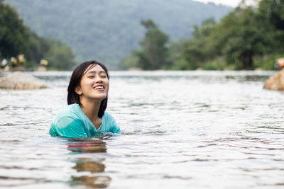 Portrait of smiling woman swimming in water