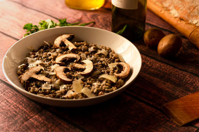 Mushroom risotto, italian food known as risotto ai funghi, top view with warm light, parsley, 