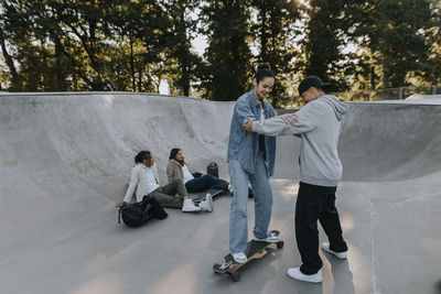 Teenage girl learning how to skate in skate park