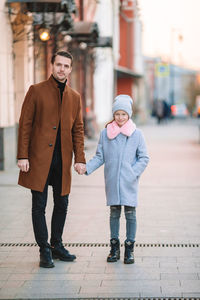 Full length portrait of man standing on footpath