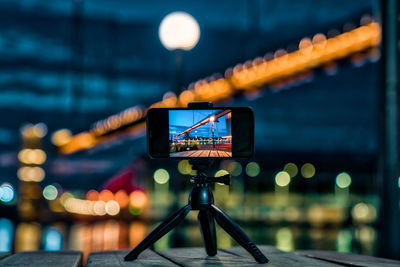 Low angle view of illuminated lighting equipment on water at night