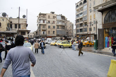 People on city street against buildings