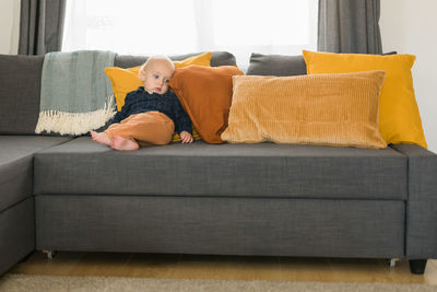 Portrait of woman sitting on sofa at home