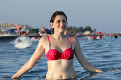 Portrait of young woman wearing red bikini in sea