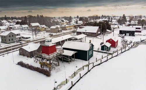 High angle view of snow covered houses against sky