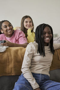 Happy female friends spending leisure time while playing in bedroom