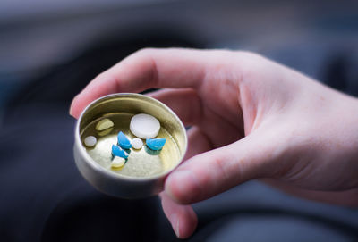 High angle view of hand holding several pills in a can